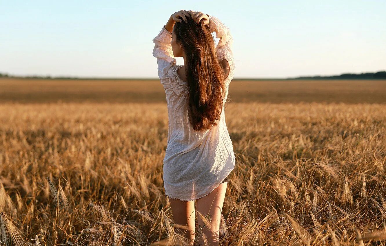 Девушка в поле со спины